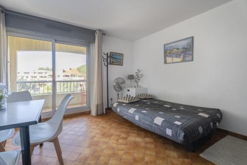 a bedroom with a bed and a table and a window at appartement pour 4 personnes in Saint-Mandrier-sur-Mer