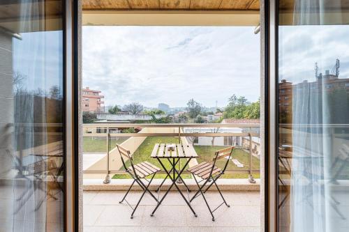 eine Terrasse mit einem Tisch und Stühlen auf dem Balkon in der Unterkunft GuestReady - Sophistication and refinement in Vila Nova de Gaia