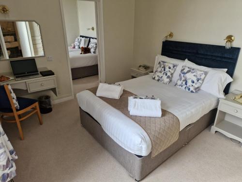 1 dormitorio con cama con espejo y escritorio en Redcliffe Hotel, en Paignton