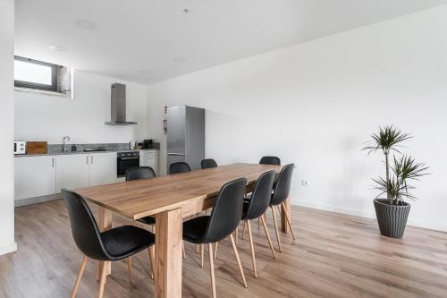 a dining room with a wooden table and black chairs at GuestReady - Casas de Fralães in Barcelos