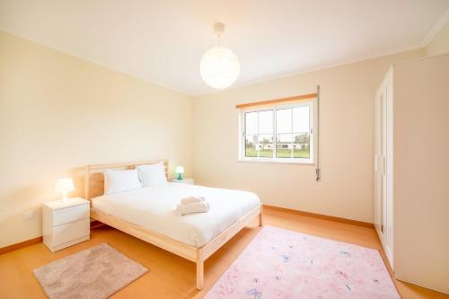 a bedroom with a white bed and a window at GuestReady - Dreamy getaway in Cartaxo in Cartaxo