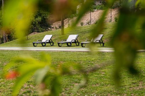 a row of park benches sitting in a park at GuestReady - Casas de Fralães in Barcelos