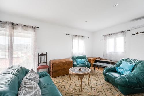 a living room with two green couches and a table at Retro-modern retreat in Esposende in Esposende