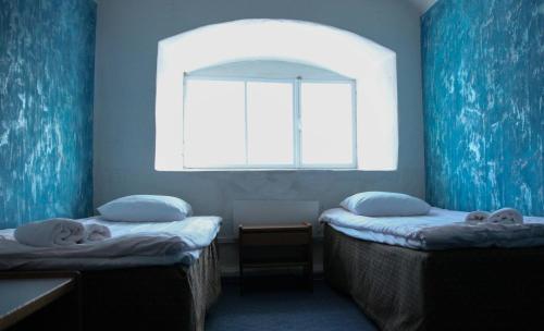 two twin beds in a room with a window at Utoopia nr 9 in Kõrgessaare