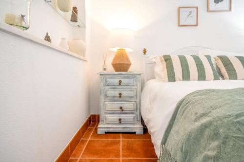 a bedroom with a bed and a night stand next to a bed at Refreshing poolside escape in Ponte de Sor in Ponte de Sor