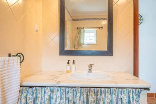 a bathroom with a sink and a mirror at Refreshing poolside escape in Ponte de Sor in Ponte de Sor