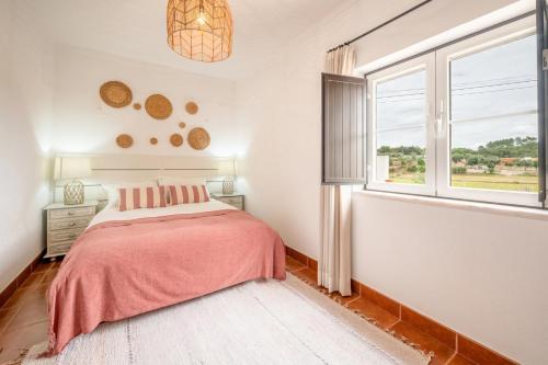 a bedroom with a bed and a window at Refreshing poolside escape in Ponte de Sor in Ponte de Sor