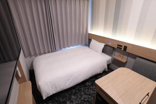a small hotel room with a bed and a desk at R&B Hotel Otsuka Eki Kitaguchi in Tokyo
