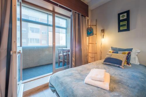 a bedroom with a bed and a large window at GuestReady - Woodwork Apartment in Porto
