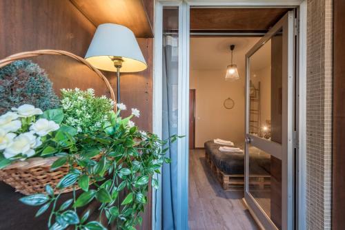 GuestReady - Woodwork Apartment في بورتو: ممر مع غرفة بها أريكة وزهور