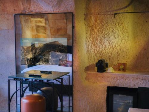 a mirror reflection of a table in a room at Very Peri Cappadocia - The Lifestyle Luxury Design Hotel in Uchisar
