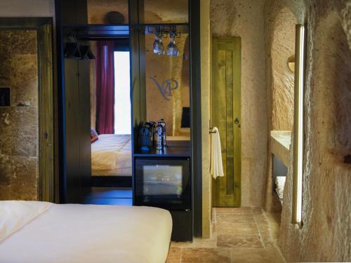a bedroom with a bed and a mirror at Very Peri Cappadocia - The Lifestyle Luxury Design Hotel in Uchisar