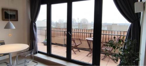 einen Balkon mit Blick auf einen Tisch und Stühle in der Unterkunft Penthouse Rooftop Neuss DÜS in Neuss