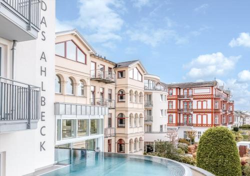 un edificio de apartamentos con piscina frente a él en Das Ahlbeck Hotel & SPA, en Ahlbeck