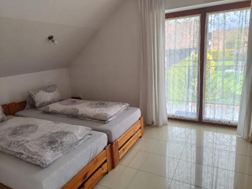 um quarto com 2 camas e uma grande janela em Privát Viktória Terchová em Terchová