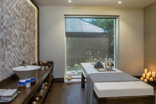 a bathroom with a tub and a sink and a window at Alaçatı Beach Resort in Yumru