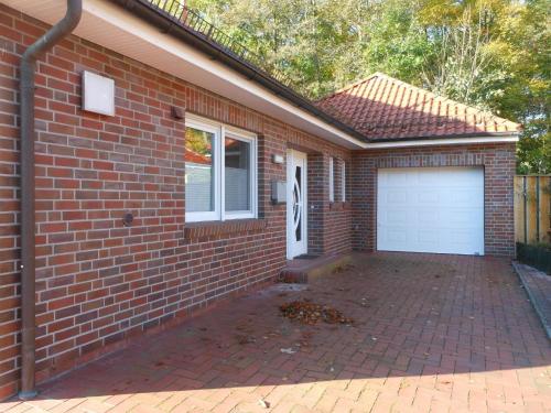 una casa de ladrillo con garaje y entrada en Bungalow Waldglück, en Hage