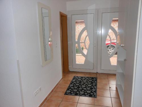 Un pasillo con una puerta con un felpudo al frente. en Bungalow Waldglück, en Hage