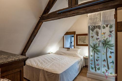una camera da letto con letto in mansarda di La maison du Cocher a Pleyber-Christ