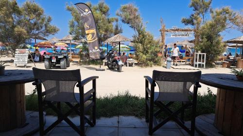 two chairs sitting at tables in front of a beach at Haus Andreas in Néa Meságkala