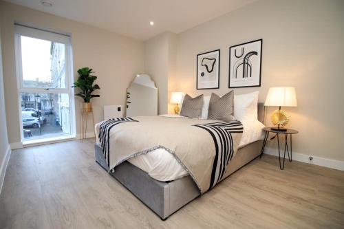 1 dormitorio con cama grande y ventana grande en Casablanca 2 - Cardiff Bay - 2 Bed Apartment, en Cardiff