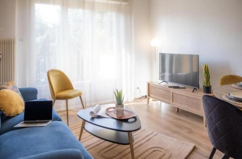 uma sala de estar com um sofá azul e uma televisão em La Robertsau, Lumineux, Paisible em Estrasburgo