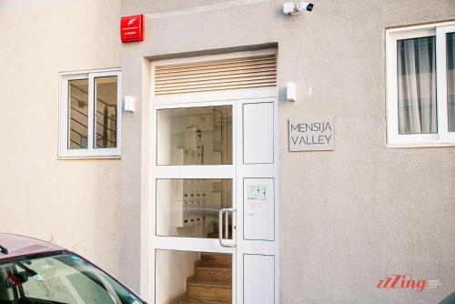 a white door to a building with a window at Mensija Valley Residences in St Julian's