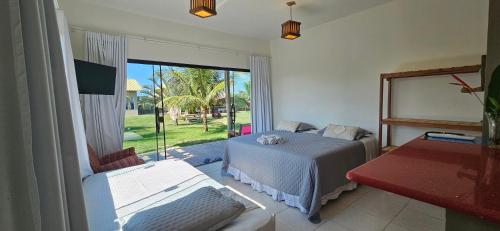 a bedroom with a bed and a large window at Kite Nômade in Arraial do Cabo