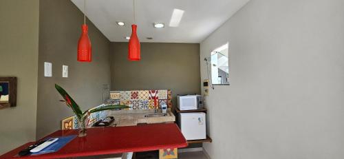 a kitchen with red pendant lights and a red table at Kite Nômade in Arraial do Cabo