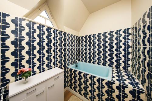Baño con azulejos azules y blancos en la pared en La Belle Etoile - Maison avec grand jardin, en Hauteville-sur-Mer