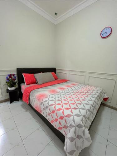 - une chambre dotée d'un lit avec une horloge murale dans l'établissement Selesa di lagenda langkawi, à Kuah