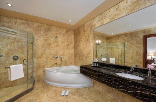 baño con bañera y espejo grande en Al Raha Beach Hotel - Superior Room SGL - UAE, en Abu Dabi