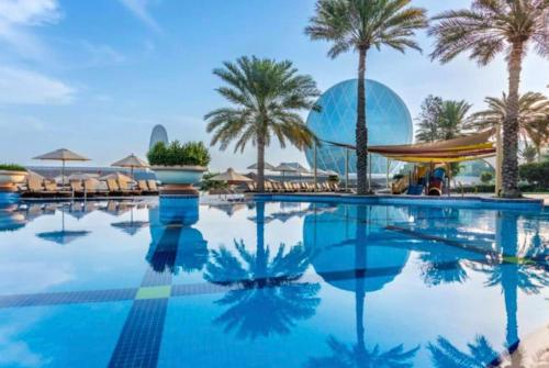 uma piscina num resort com palmeiras em Al Raha Beach Hotel - Superior Room SGL - UAE em Abu Dhabi