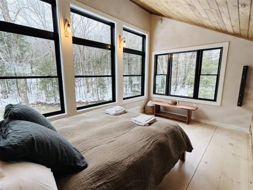 a bedroom with large windows and a large bed at West Branch 75, Waterville Valley in Waterville Valley