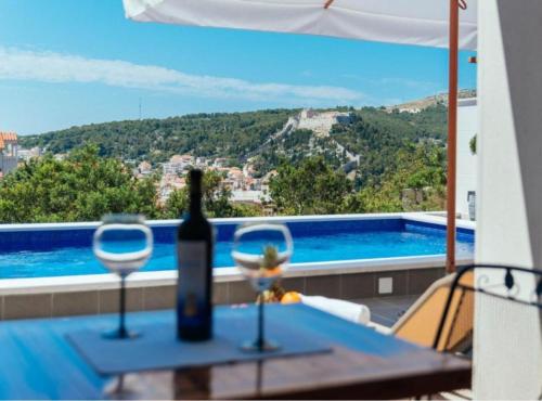 uma mesa com uma garrafa de vinho e dois copos em Apartments Trogrlić em Hvar