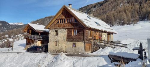 a log cabin in the snow with a car in front at Chalet prestige front de neige 14 pers in Ceillac