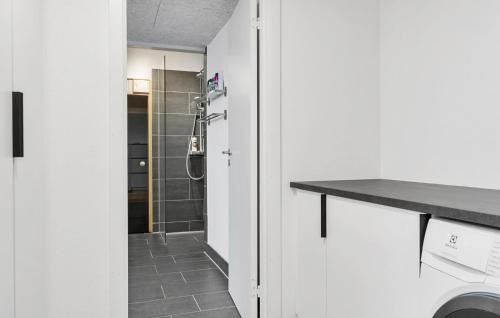 La salle de bains est pourvue d'une douche à l'italienne et d'un lavabo. dans l'établissement Gorgeous Home In Saltum With Sauna, à Saltum