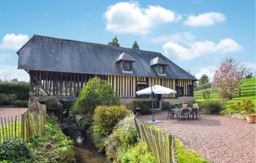 a large wooden house with a table and an umbrella at Stunning Home In Stmarguerite Dloges in Sainte-Marguerite-des-Loges
