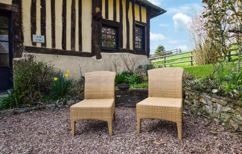 two wicker chairs sitting in front of a house at Stunning Home In Stmarguerite Dloges in Sainte-Marguerite-des-Loges