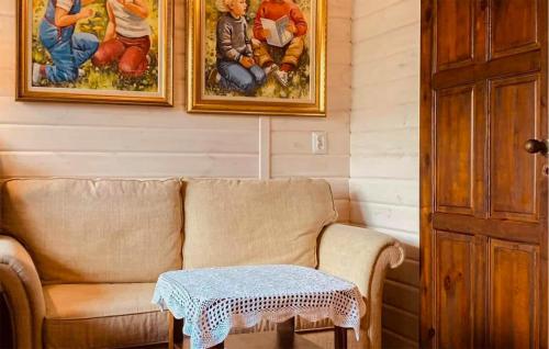 WęgorzynoCozy Apartment In Wegorzyno With Wifi的客厅里有一张沙发，墙上挂着画