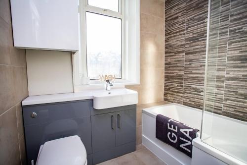uma casa de banho com um lavatório, um WC e uma janela. em West Beck House - Newcastle 3 em North Shields