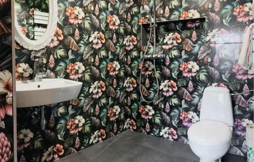 a bathroom with a toilet and a flower wallpaper at Amazing Apartment In Wegorzyno With Outdoor Swimming Pool in Węgorzyno