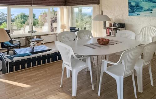 a dining room with a table and white chairs at Lovely Home In Porticcio With Wifi in Porticcio