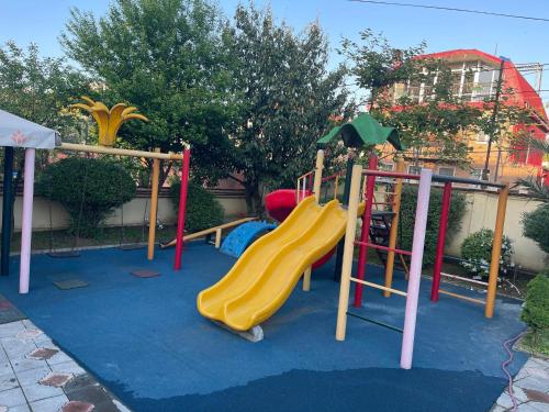 a playground with a slide on a blue carpet at Hotel Buta in Batumi