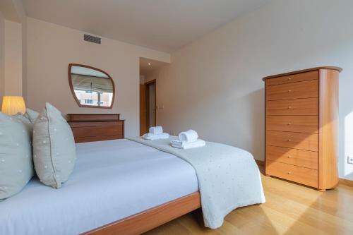 a bedroom with a large white bed and a dresser at 2 Bedroom Large apartment By Innkeeper in Lisbon