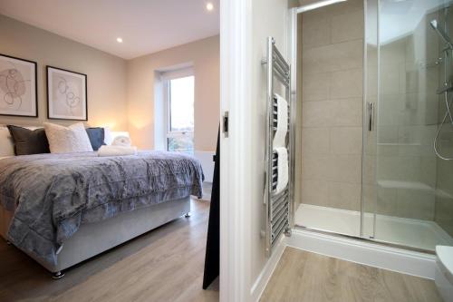 ein Schlafzimmer mit einem Bett und einer Dusche in der Unterkunft Casablanca 1 - Cardiff Bay - 2 Bed Apartment in Cardiff