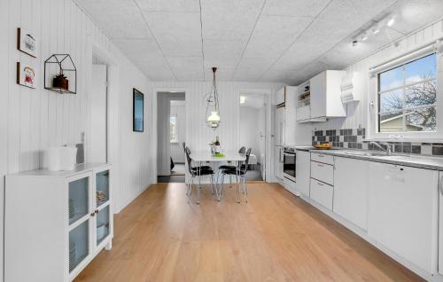 a kitchen with white cabinets and a table with chairs at Nice Home In Haderslev With Wifi in Haderslev