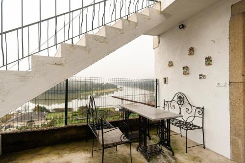 a balcony with a table and chairs and a staircase at Casa Curva do Rio in Melres