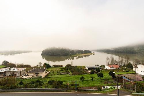 a view of a lake with houses and a town at Casa Curva do Rio in Melres