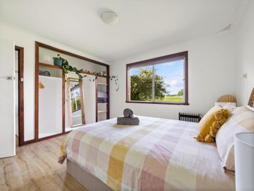 a bedroom with a large bed and large windows at Farm View Cottage in Margaret River Town